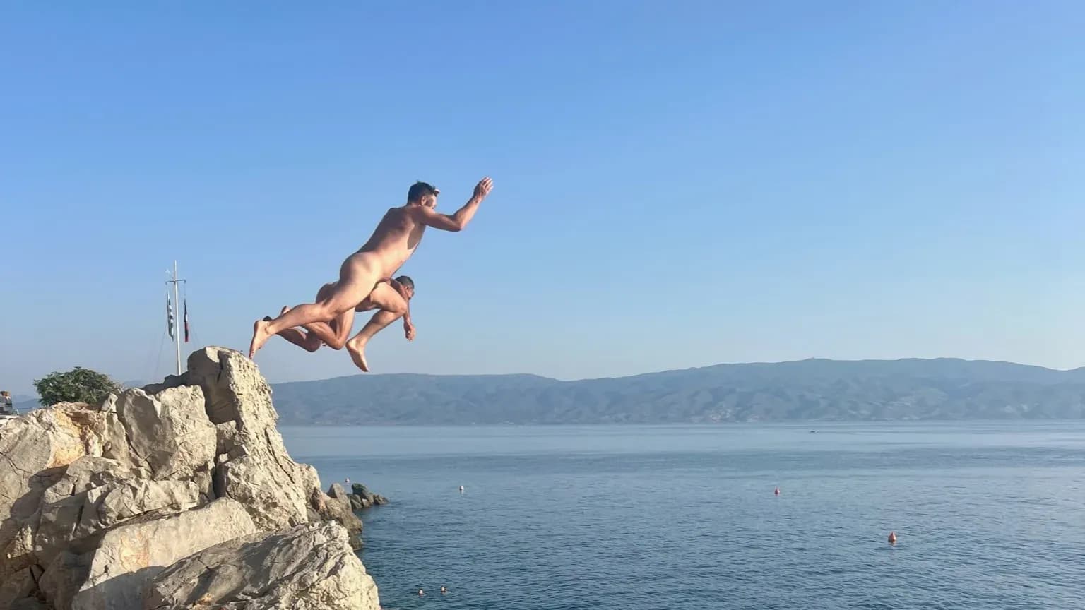 Jumping off a rocky point into the sea in Greece