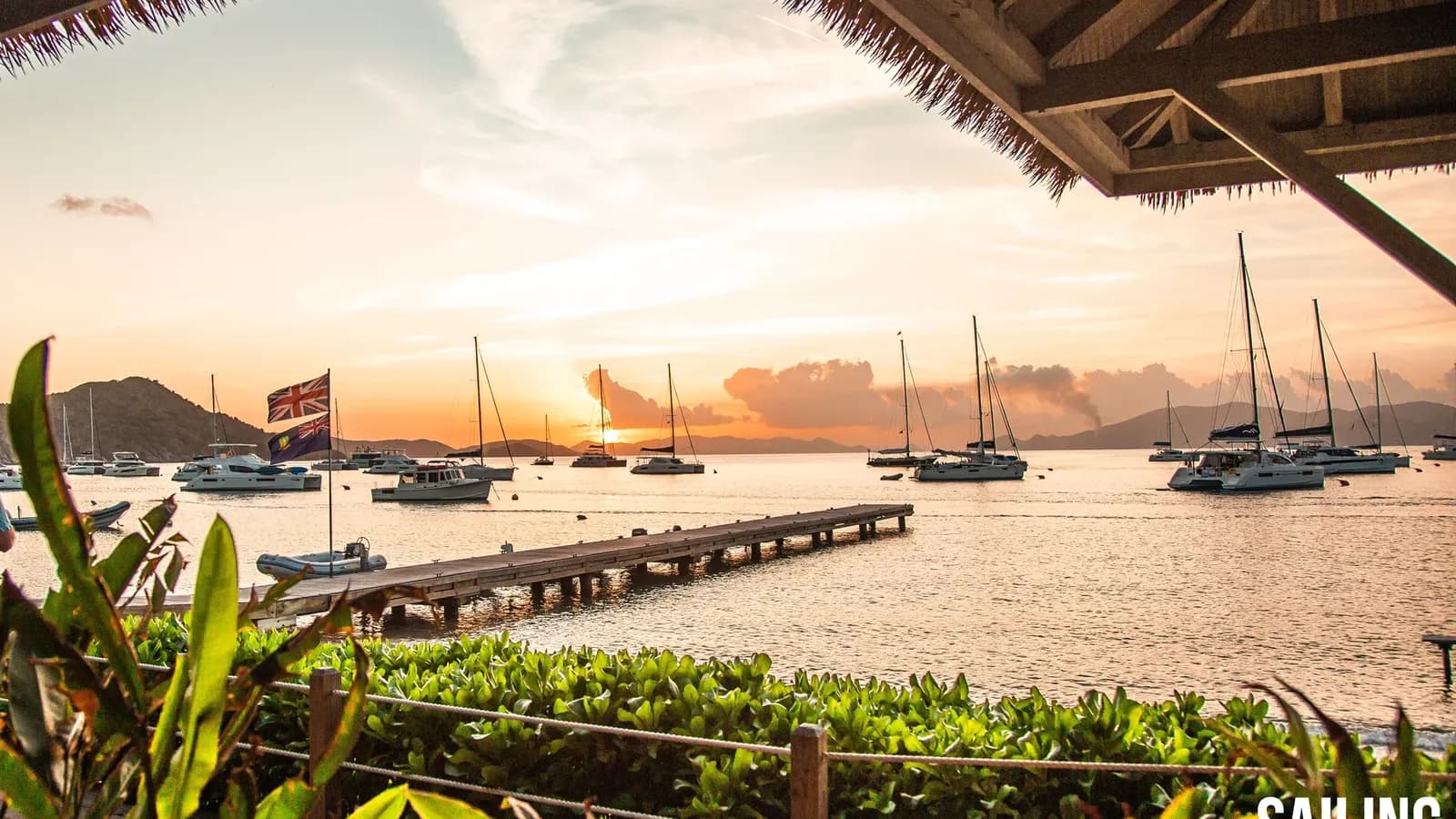 Sunset over yachts at anchor, seen from a beach bar dock