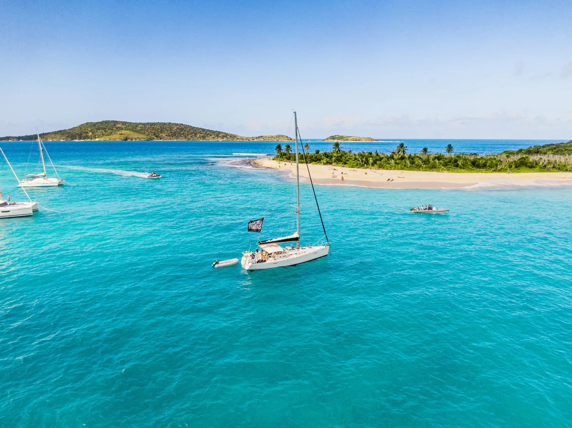 Aerial view of yacht anchored near turquoise sandbar