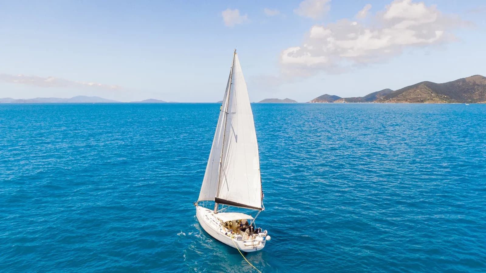 A sailboat under full sail on open Caribbean water