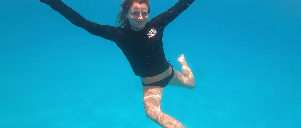 A Sailing Virgins student swimming underwater in clear blue water